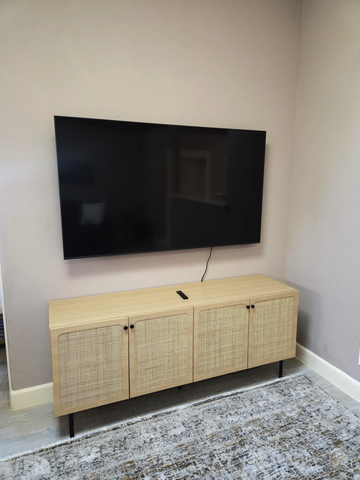 A bright living area with a large flat-screen TV and a light wood media console, inviting for movie nights or casual relaxation with family and friends.